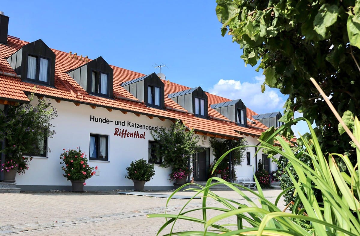 Das Hauptgebäude der Hunde- und Katzenpension Riffenthal mit Hausschild und Blumenschmuck